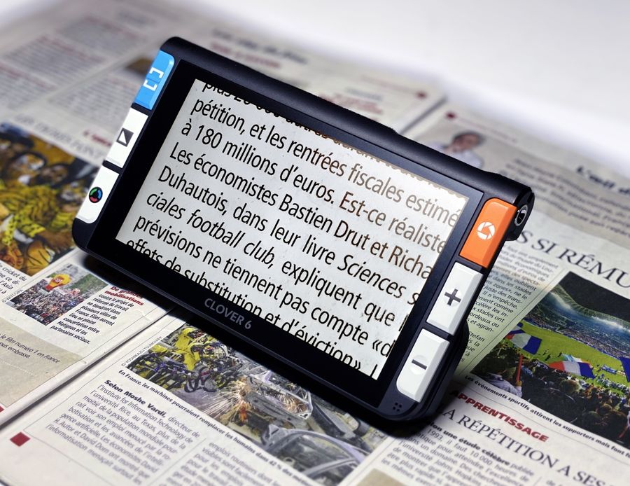 Loupe électronique CLOVER 6 posée sur un journal